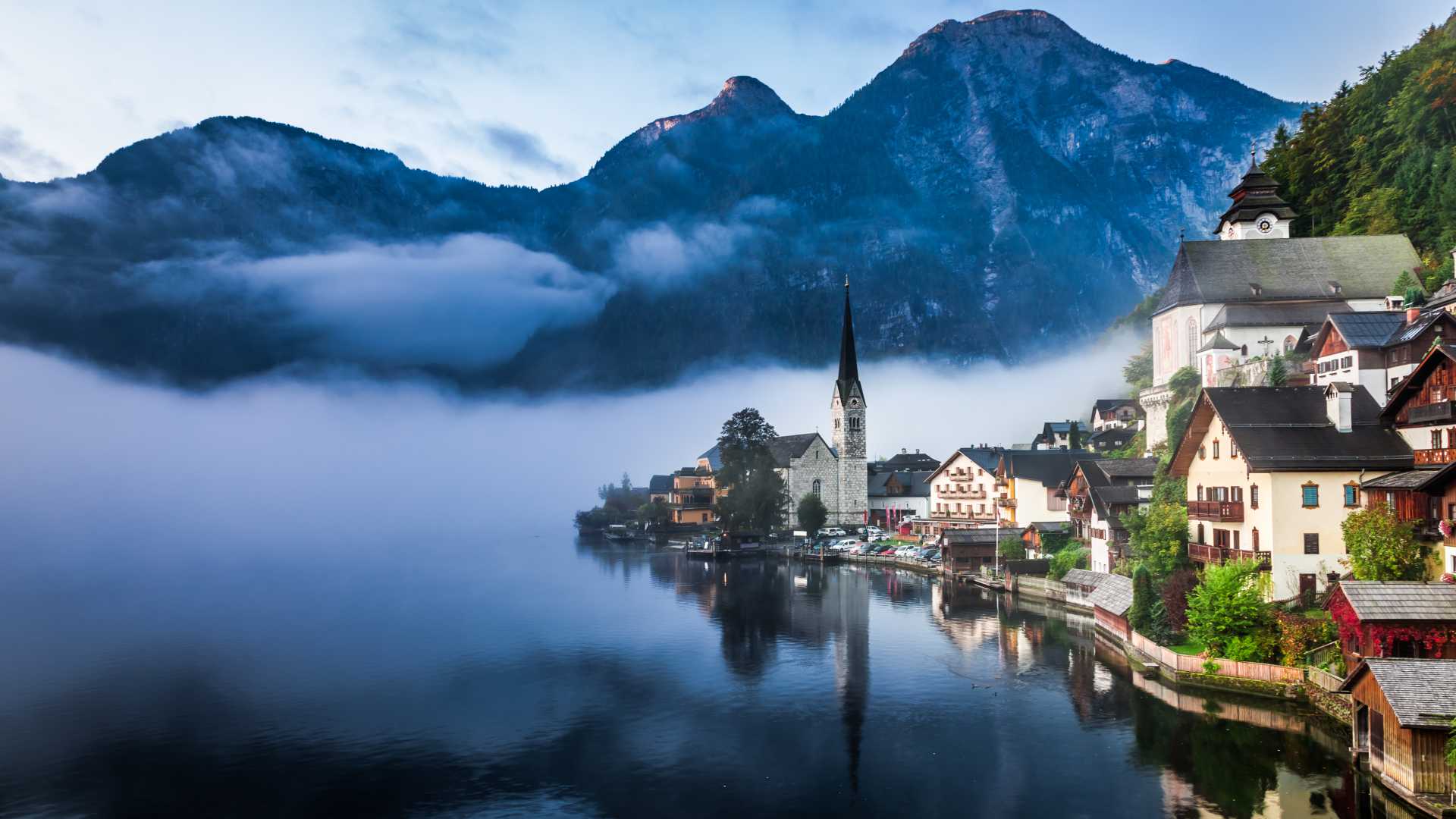Una vista brumosa del amanecer de Hallstatt, Austria, que muestra su encantador pueblo junto al lago y su impresionante telón de fondo montañoso.