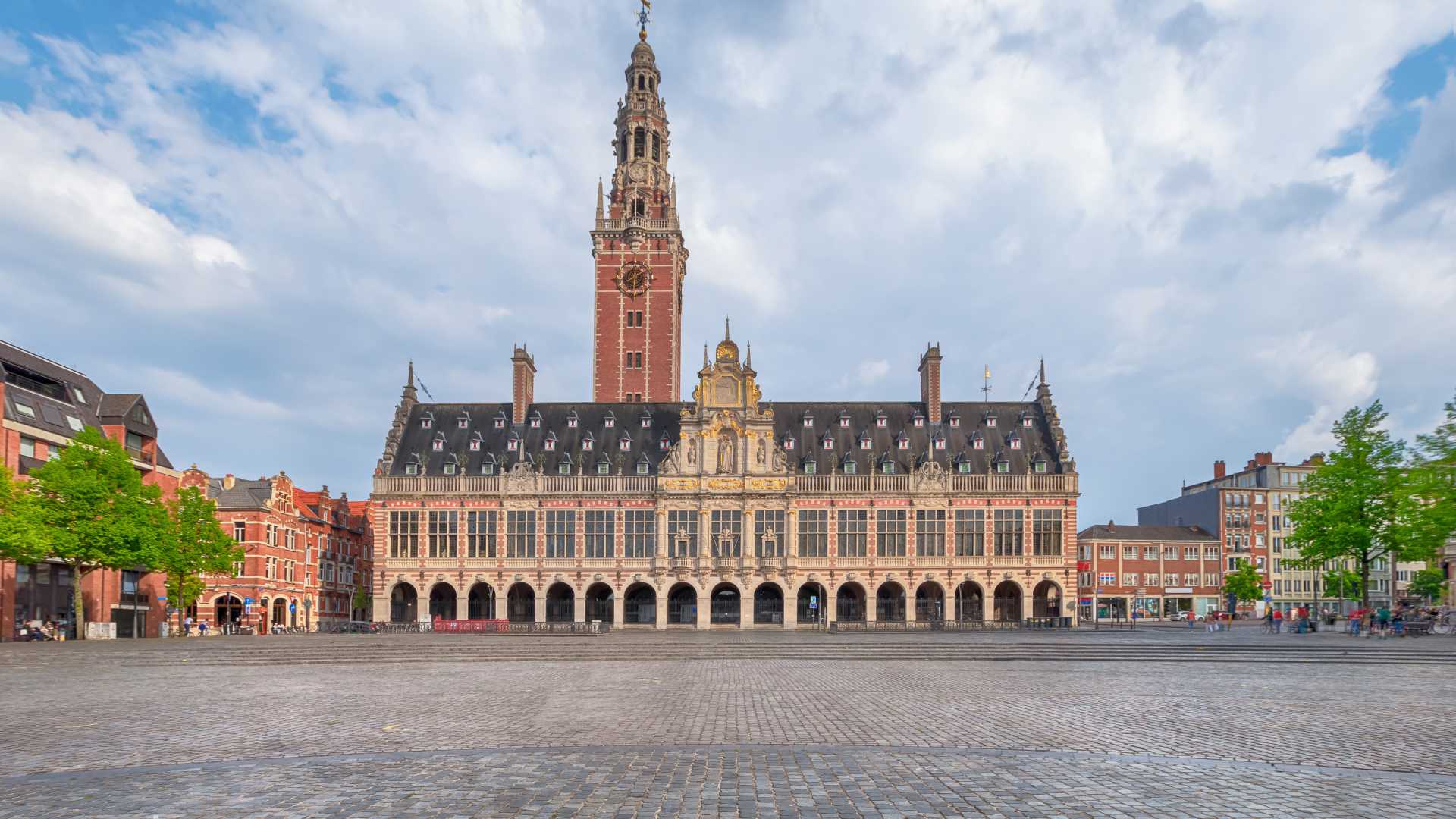 The University Library of Leuven on Ladeuze Square under a partly cloudy sky.