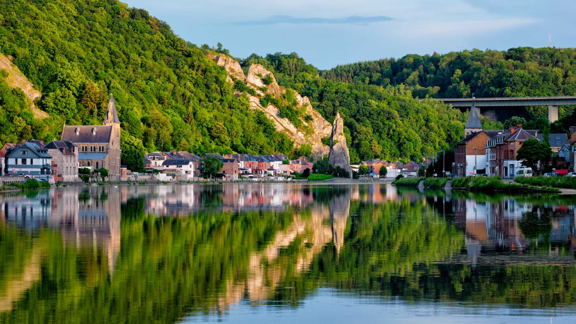 Charming Dinant reflected in the Meuse River, featuring Bayard Rock and the iconic Citadel.