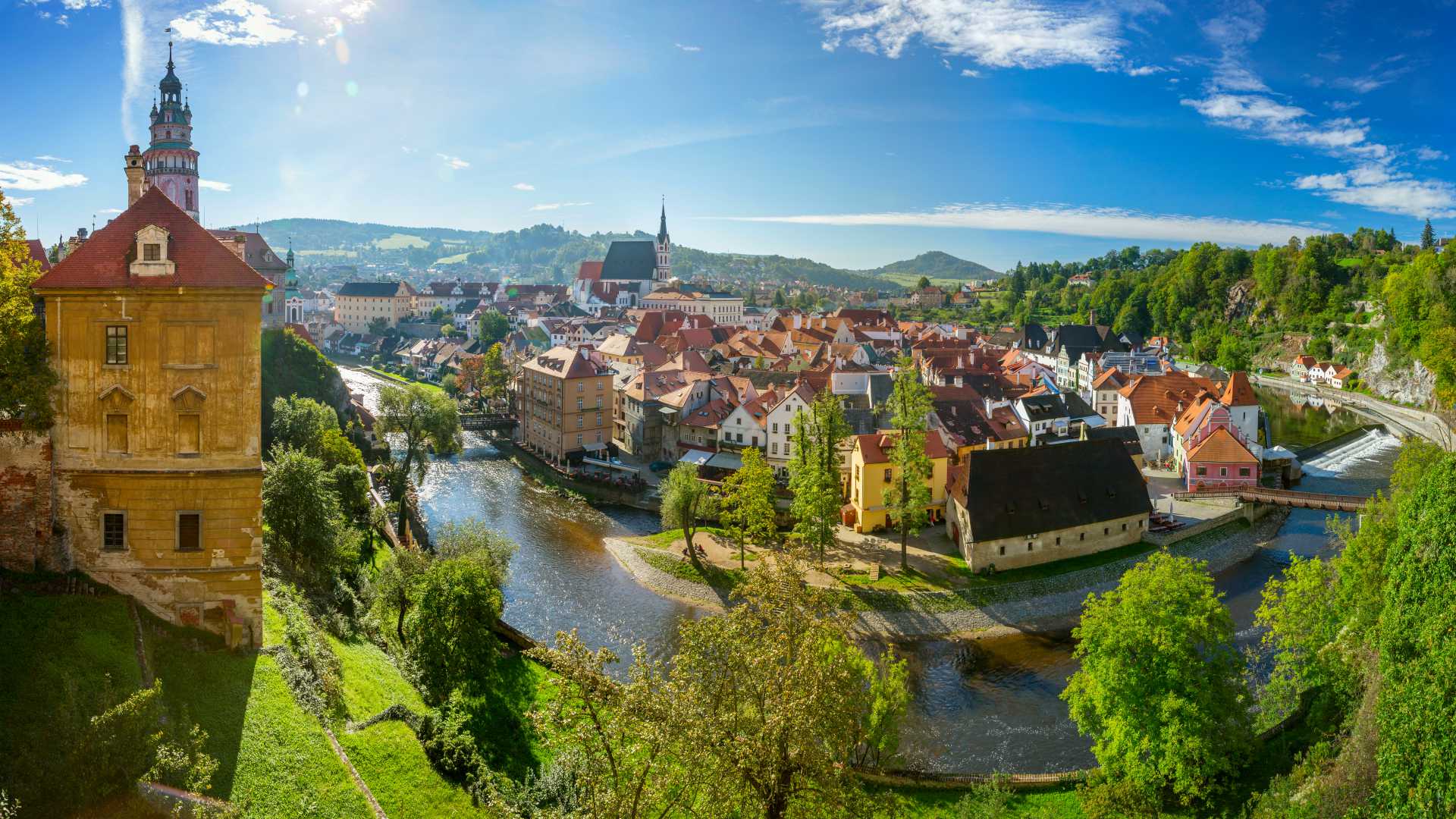 Panoramisch uitzicht op Český Krumlov met zijn middeleeuwse architectuur, kronkelende rivier en levendig groen.