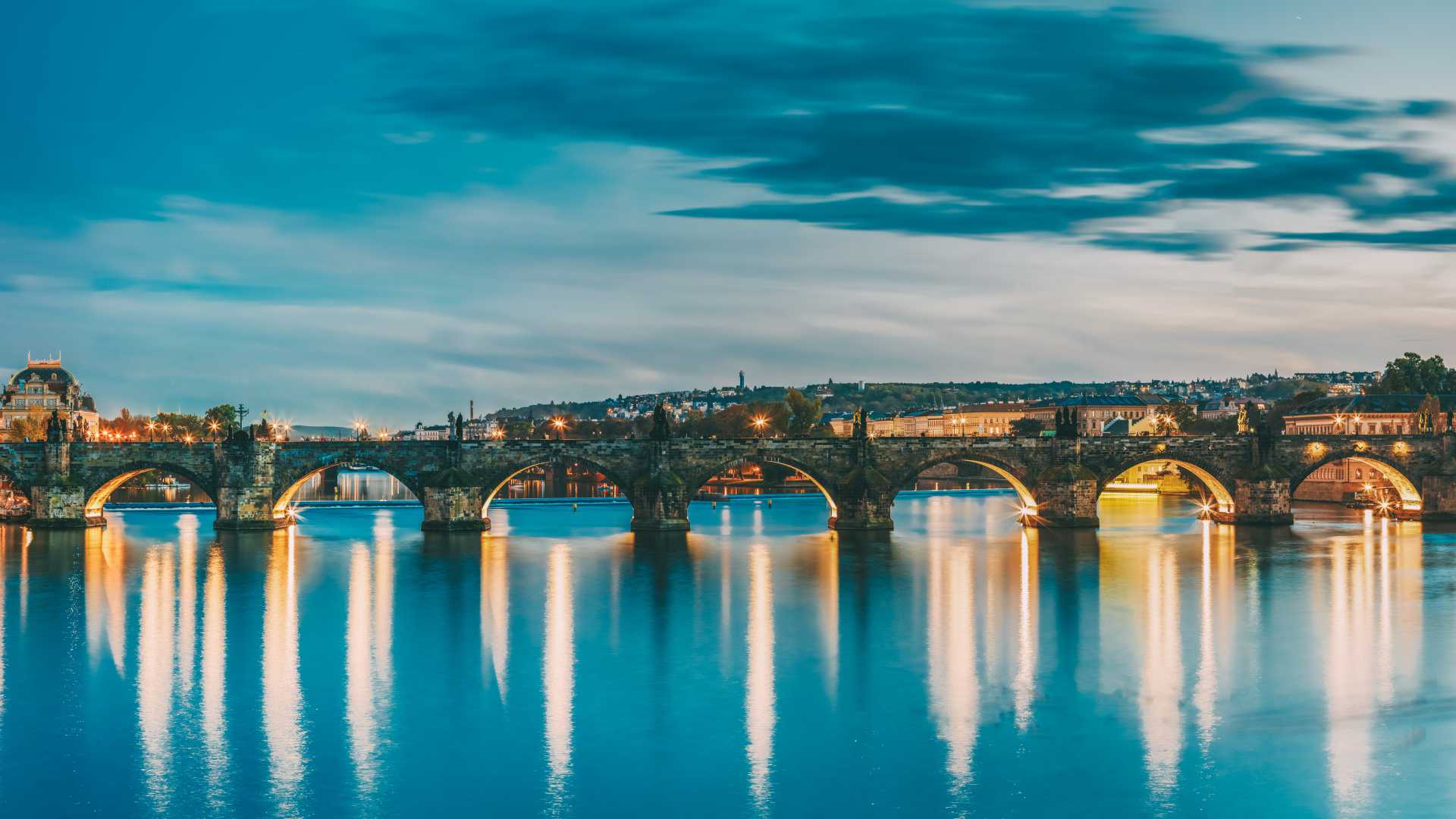De Karelsbrug in Praag, 's nachts verlicht, weerspiegeld in de Moldau.