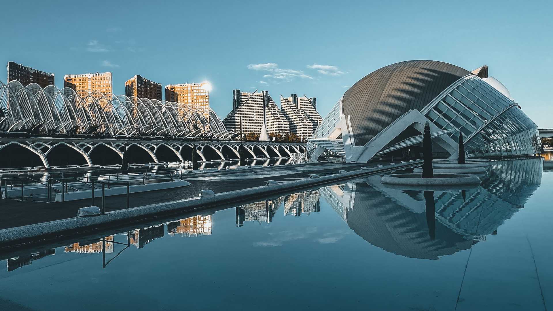 Futuristische gebouwen in Valencia weerspiegelen in een sereen zwembad en tonen de Stad van Kunst en Wetenschap.