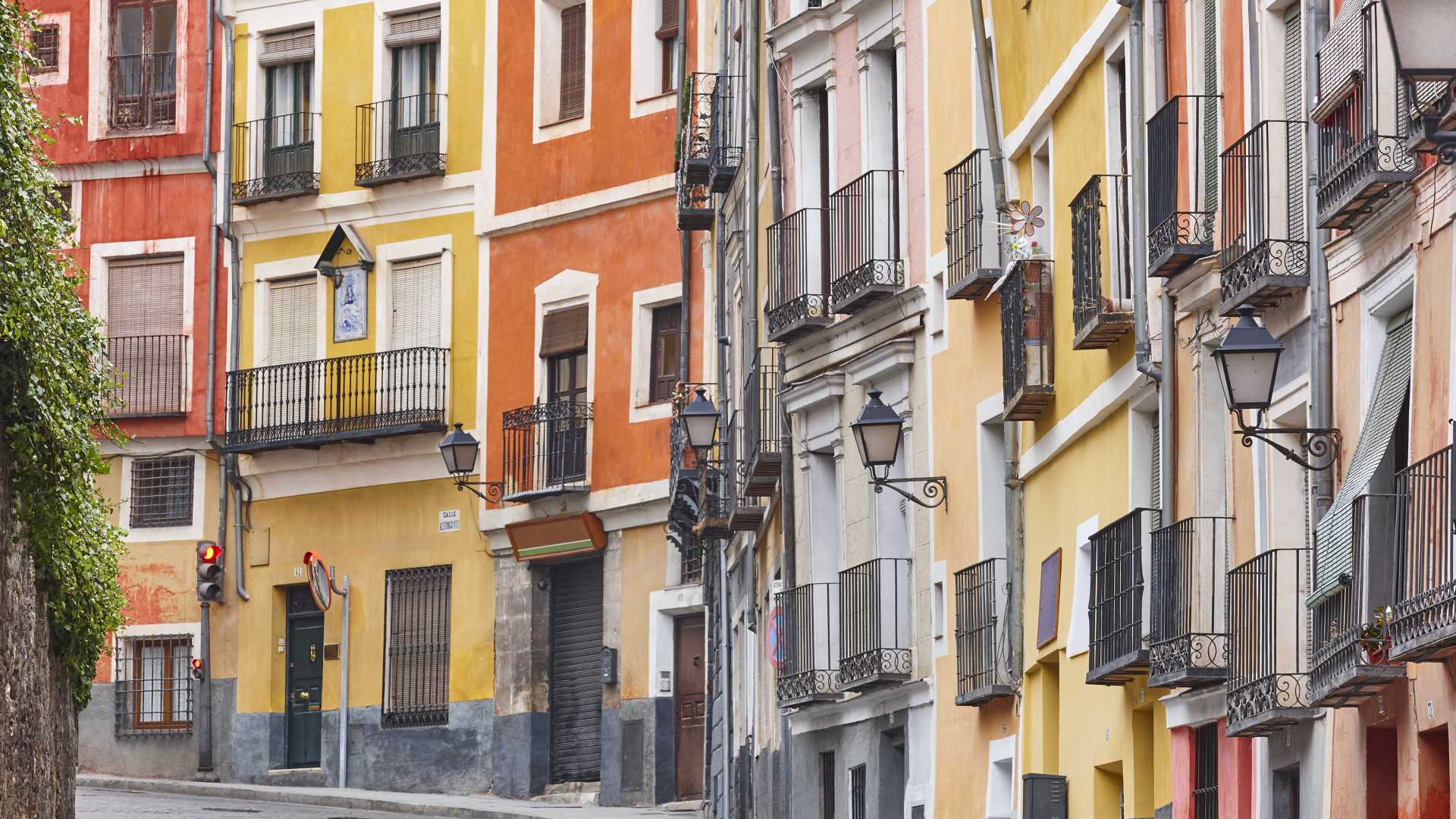 Colorful facades line a charming street in Cuenca's UNESCO heritage old town, Spain.