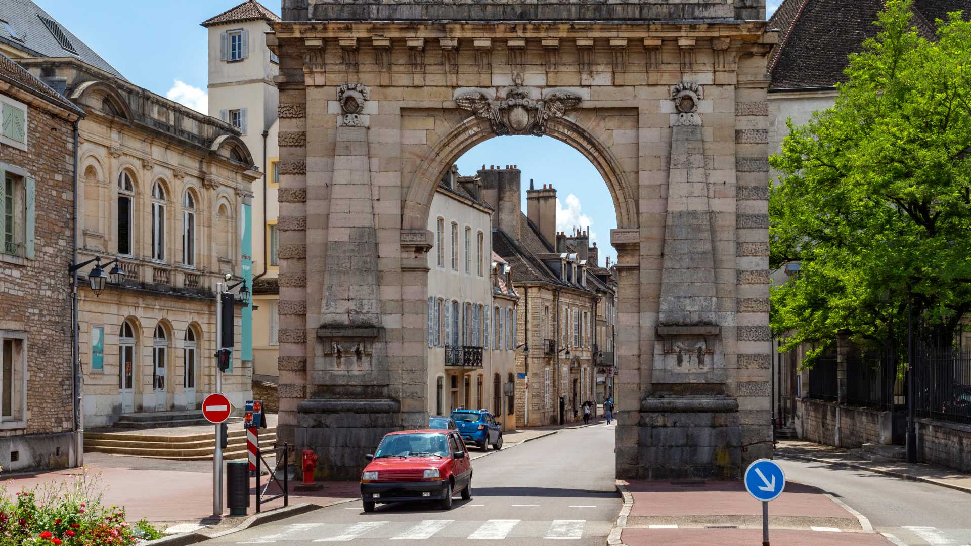 Porte St. Nicolas-boog in Beaune, Bourgondië, met historische gebouwen en groen.