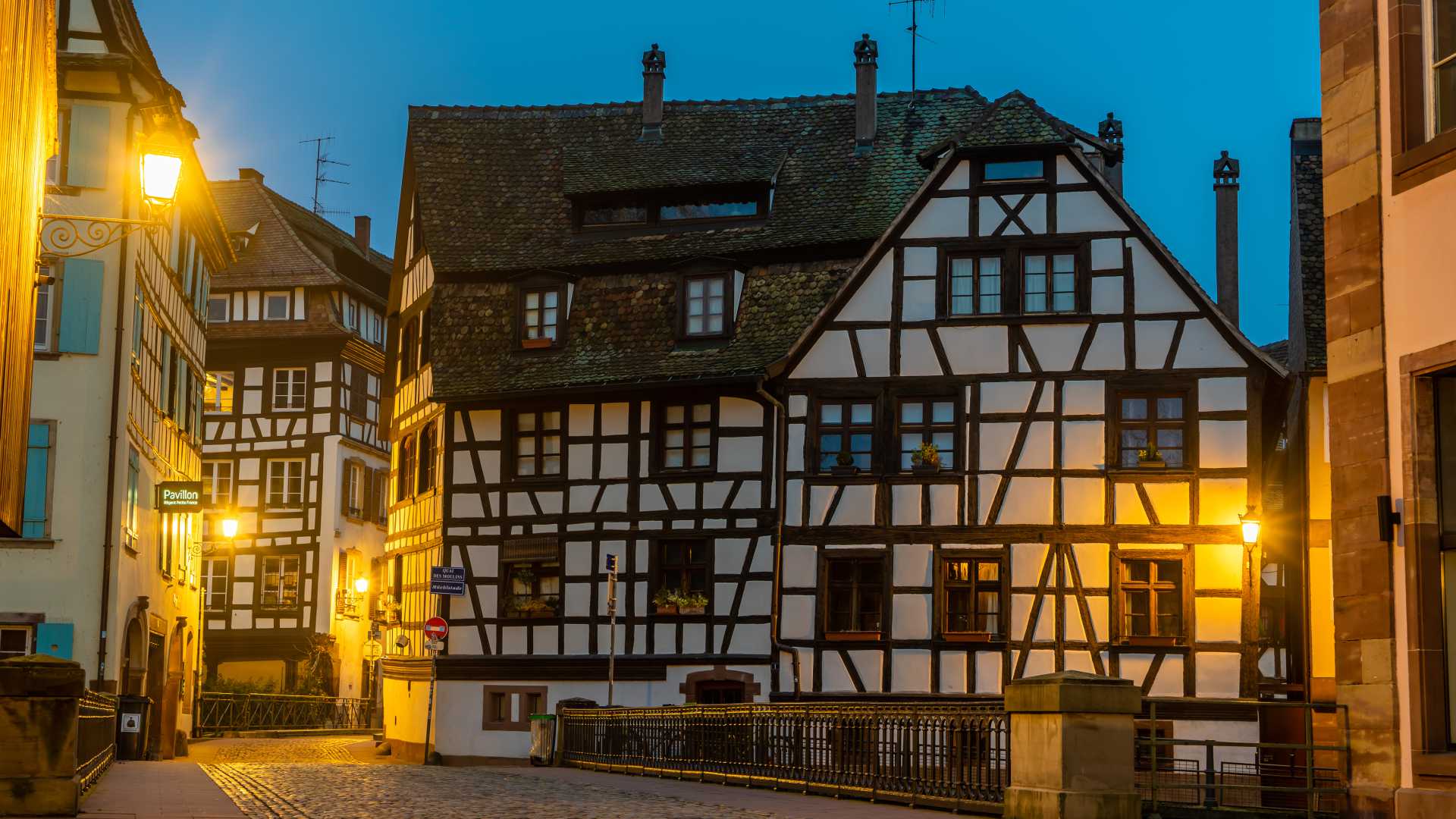 황혼에 가로등에 불이 켜진 스트라스부르 쁘띠 프랑스의 목조 가옥.