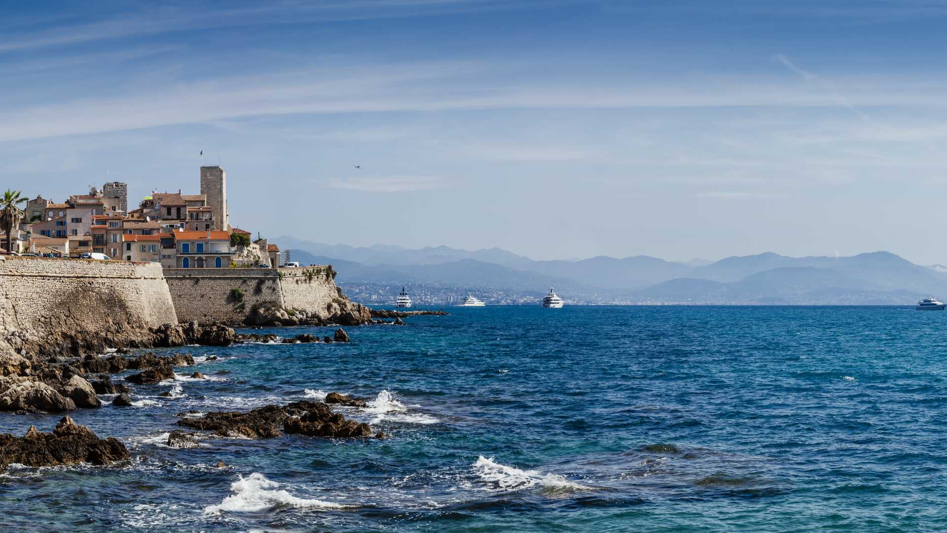 Panoramic view of Antibes' medieval fortifications and azure Mediterranean waters on the French Riviera.