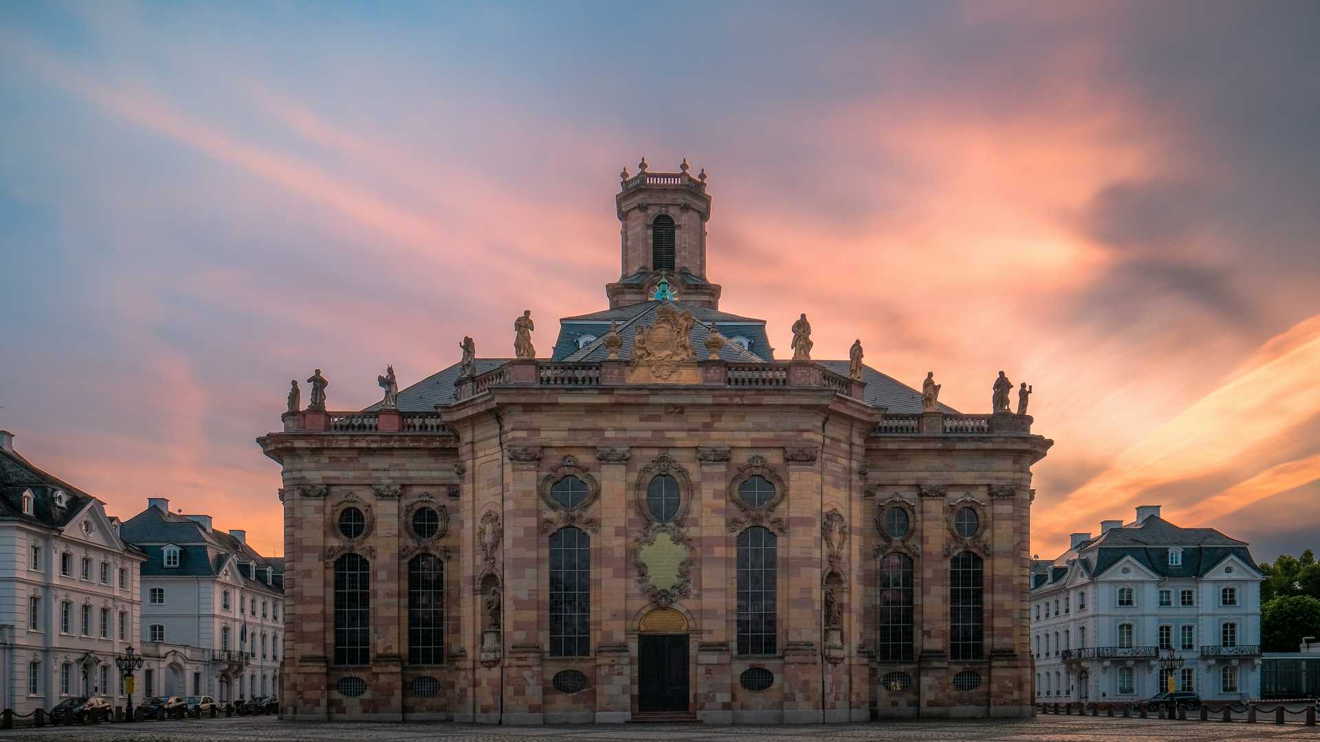 Ludwigskirche in Saarbrücken at sunset with pastel skies.