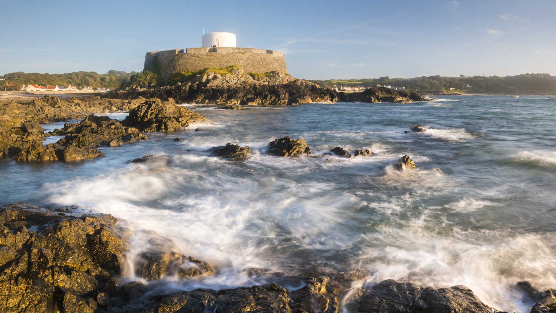 Fort Grey on Guernsey's rugged coast, a historic Martello tower battered by crashing waves.
