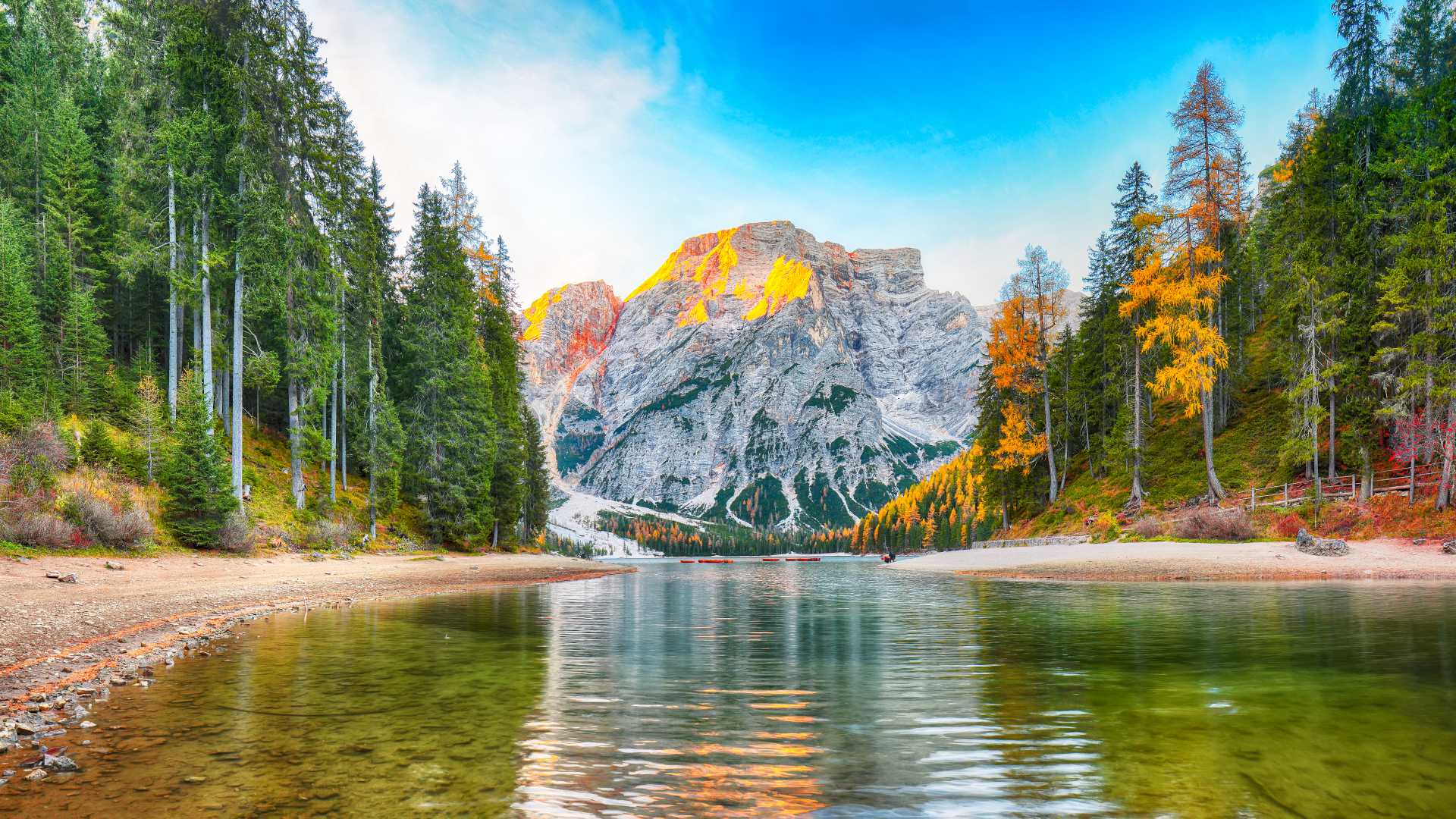 Lake Braies reflecting Dolomite peaks and autumnal forests in Trentino-Alto Adige.
