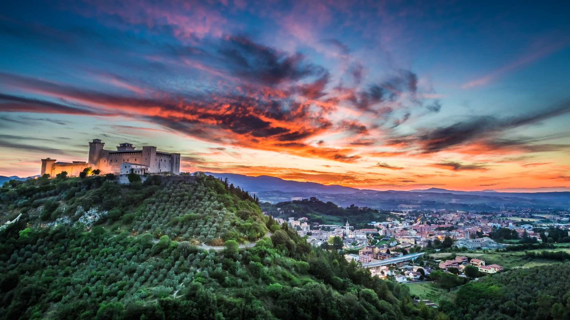 Rocca Albornoziana kasteel afgetekend tegen een levendige zonsondergang in Spoleto, Umbrië.