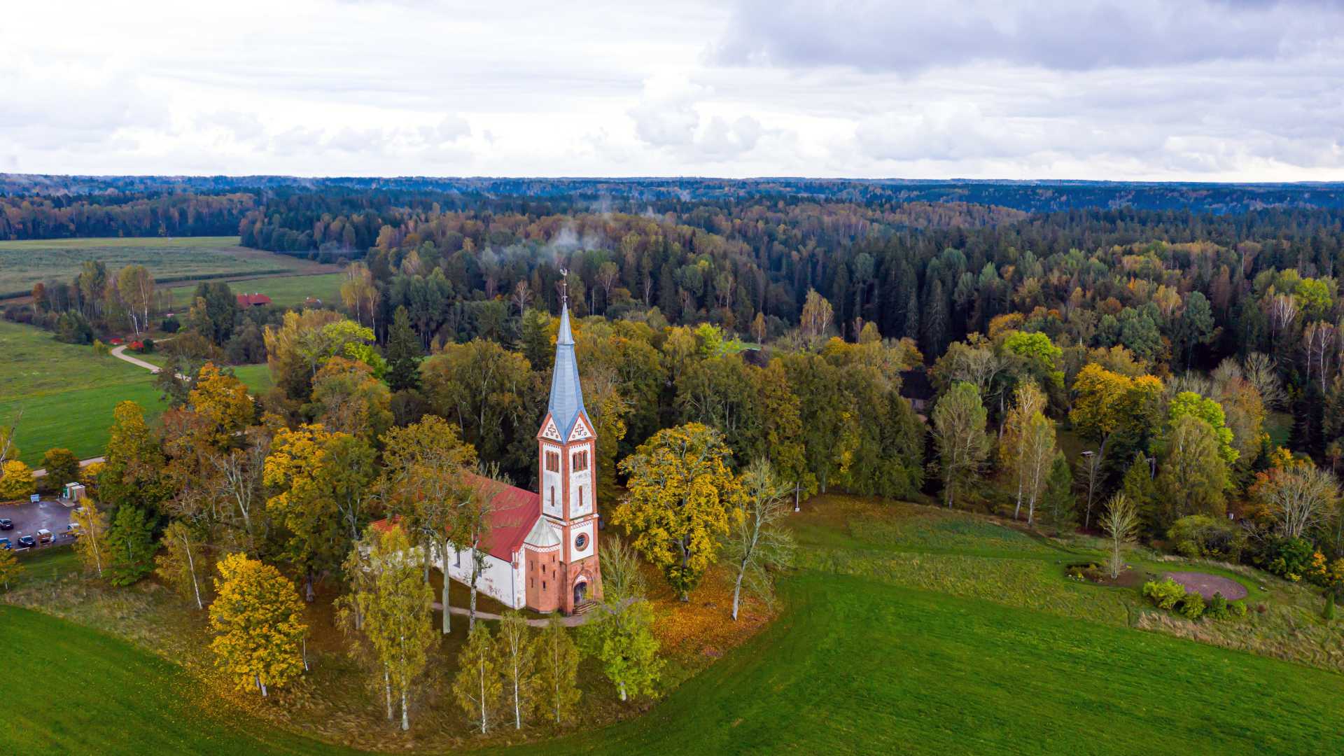Luchtfoto van de Evangelisch-Lutherse Kerk van Krimulda, omgeven door herfstblad in Letland.
