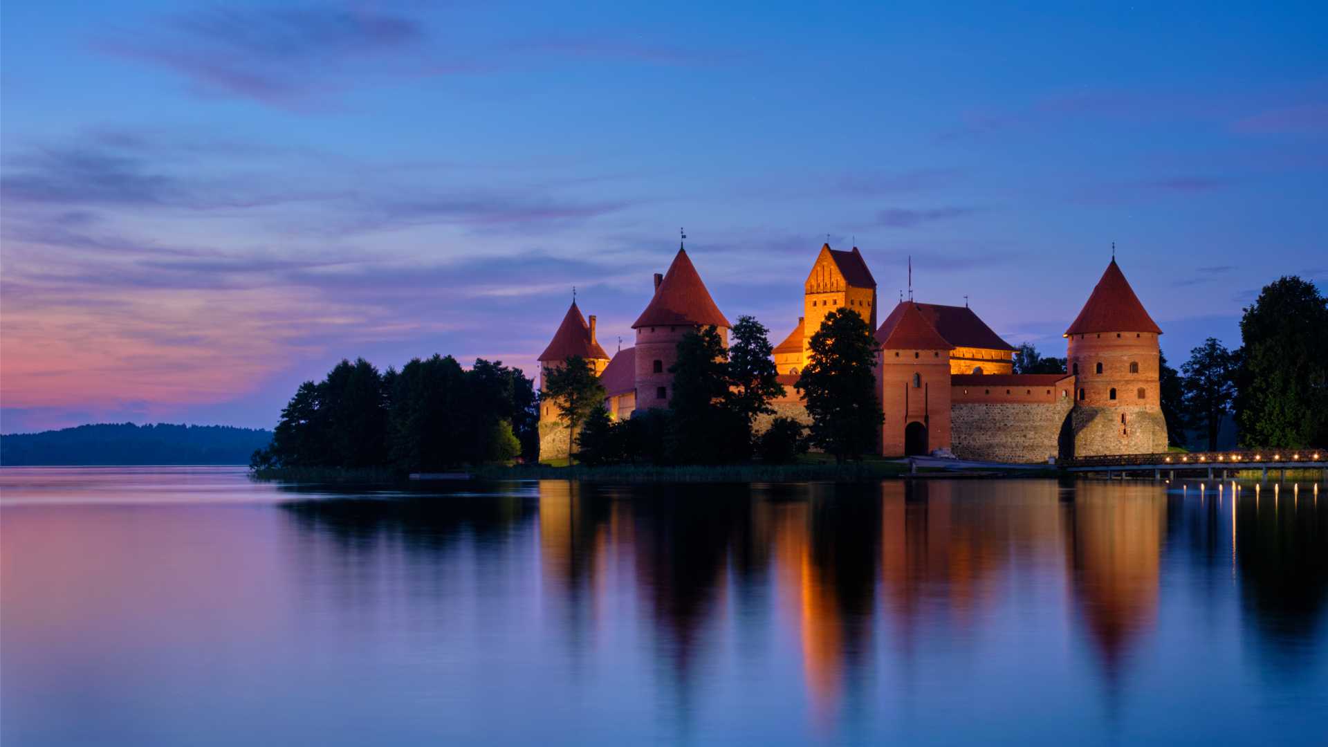 Trakai Island Castle glowing at twilight, reflected in Lake Galvė, Lithuania