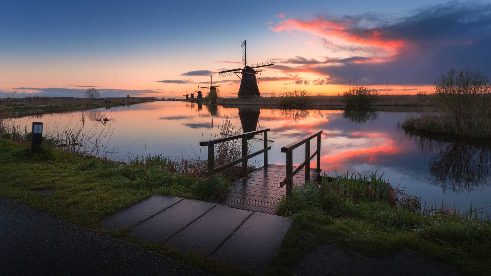 Windmolens in Kinderdijk, Nederland, bij zonsopgang, weerspiegeld in kanalen.