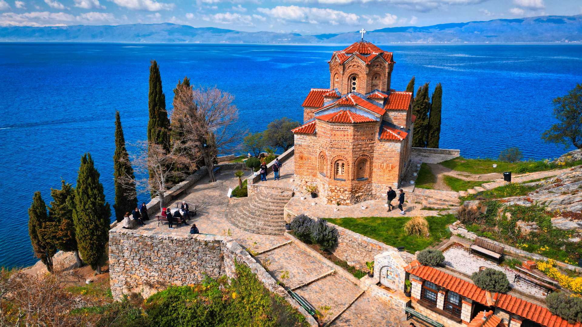 De Kerk van Sint Johannes in Kaneo kijkt dramatisch uit over het glinsterende water van het meer van Ohrid.