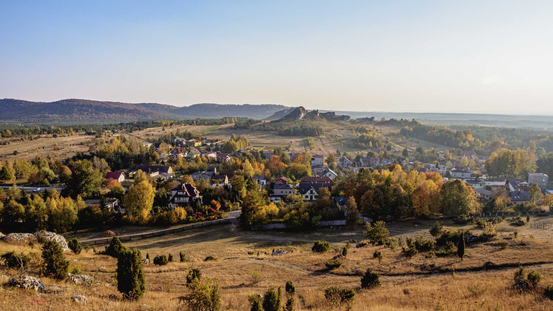 Een schilderachtig herfstuitzicht op Olsztyn, Polen, met kleurrijke bomen en glooiende heuvels.