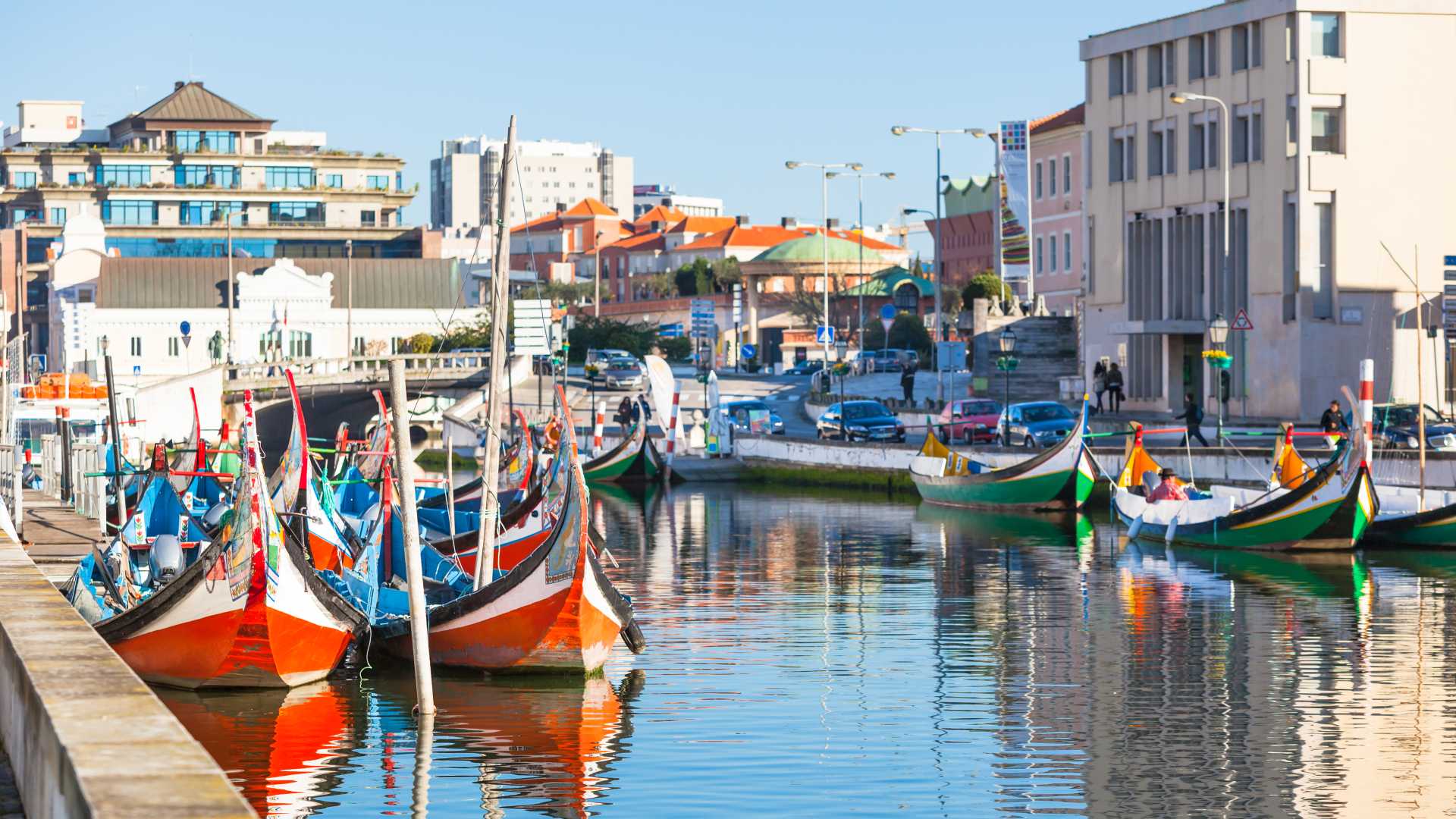 Brightly painted gondolas line a canal in Aveiro, Portugal.