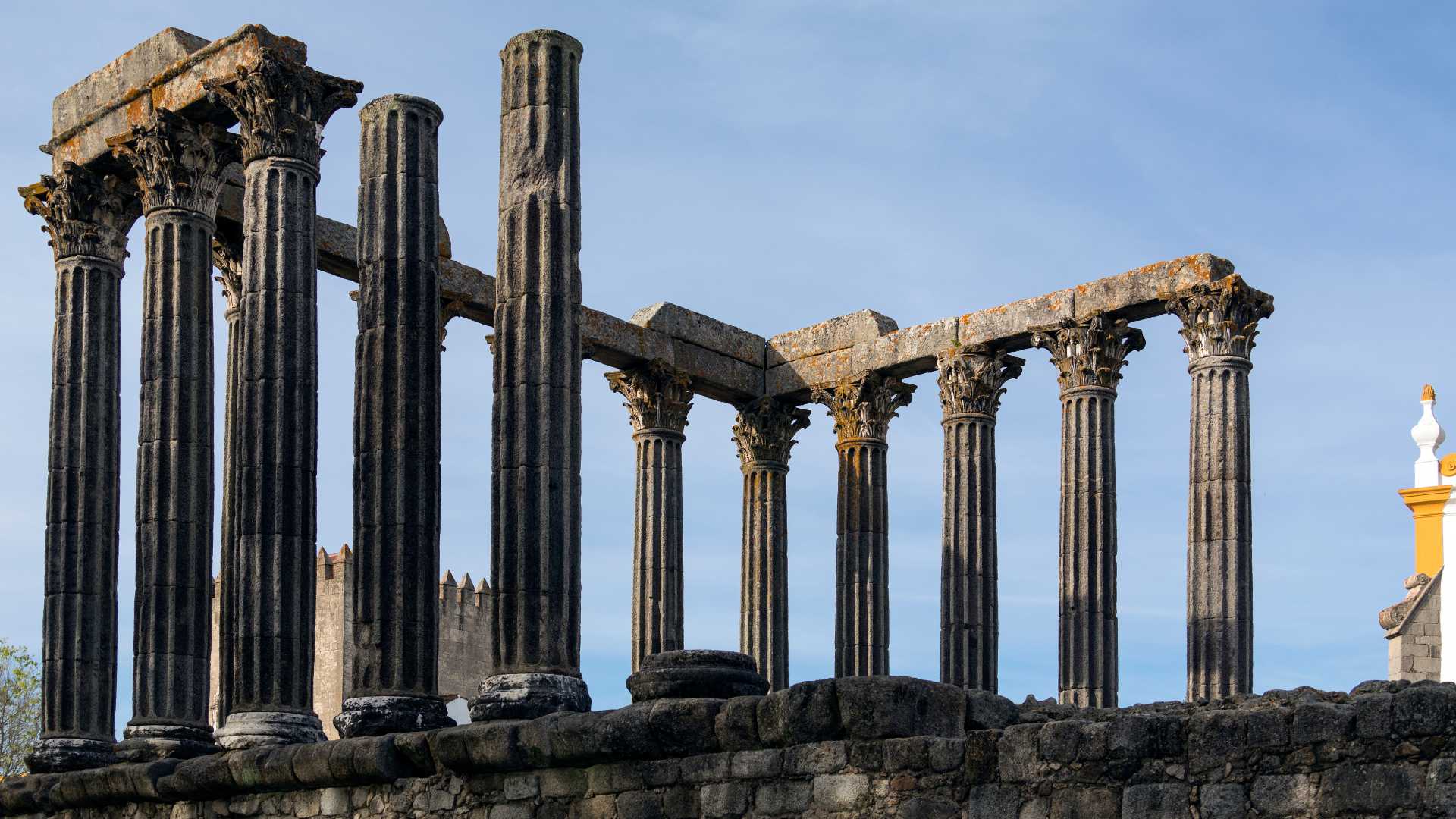 맑은 하늘 아래 우뚝 솟은 기둥이 특징인 포르투갈 에보라의 고대 로마 디아나 신전입니다.