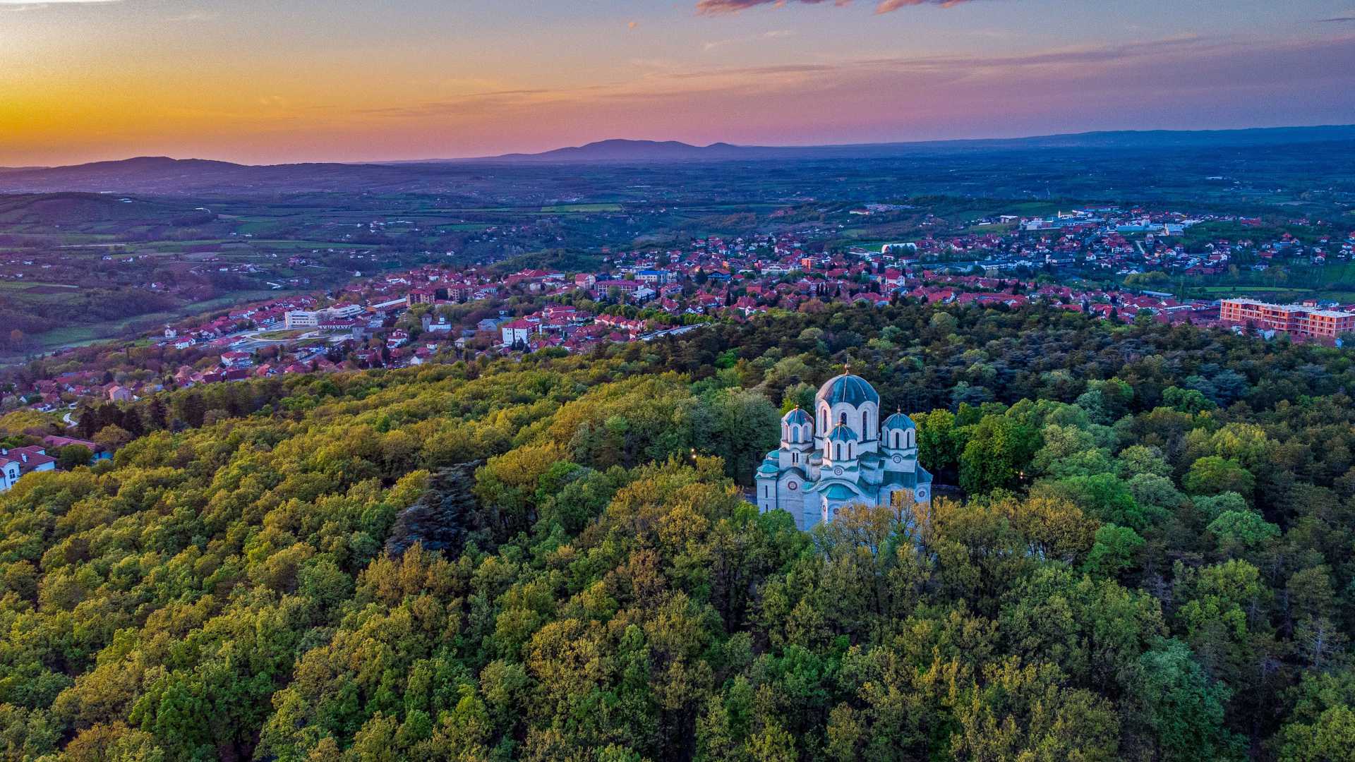 Luchtfoto van de St Georgekerk, omgeven door een weelderig bos in Oplenac, Topola, Servië.