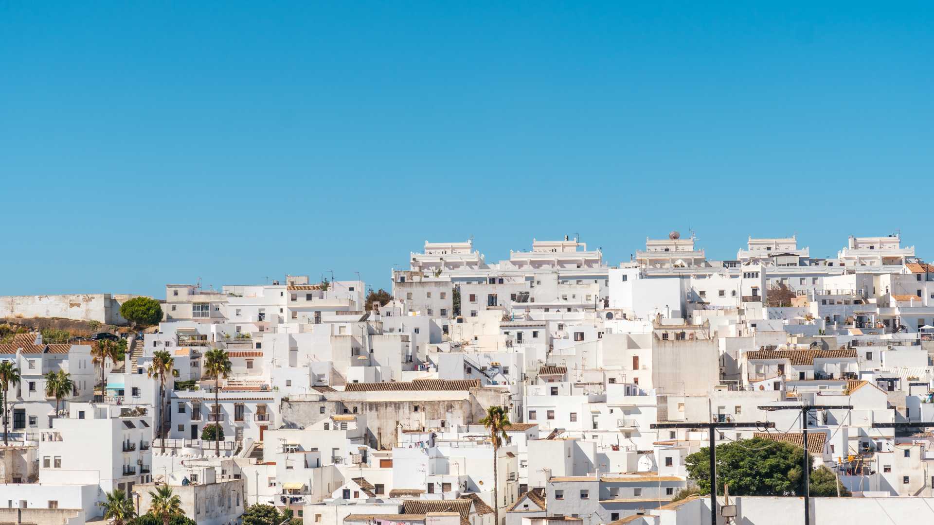 Witgekalkte huizen van Vejer de la Frontera, Andalusië, onder een helderblauwe lucht.