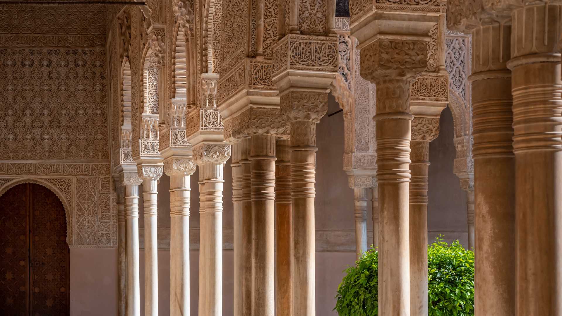 Ingewikkeld gesneden Moorse bogen en zuilen in het Leeuwenhof, Alhambra, Granada, Spanje.