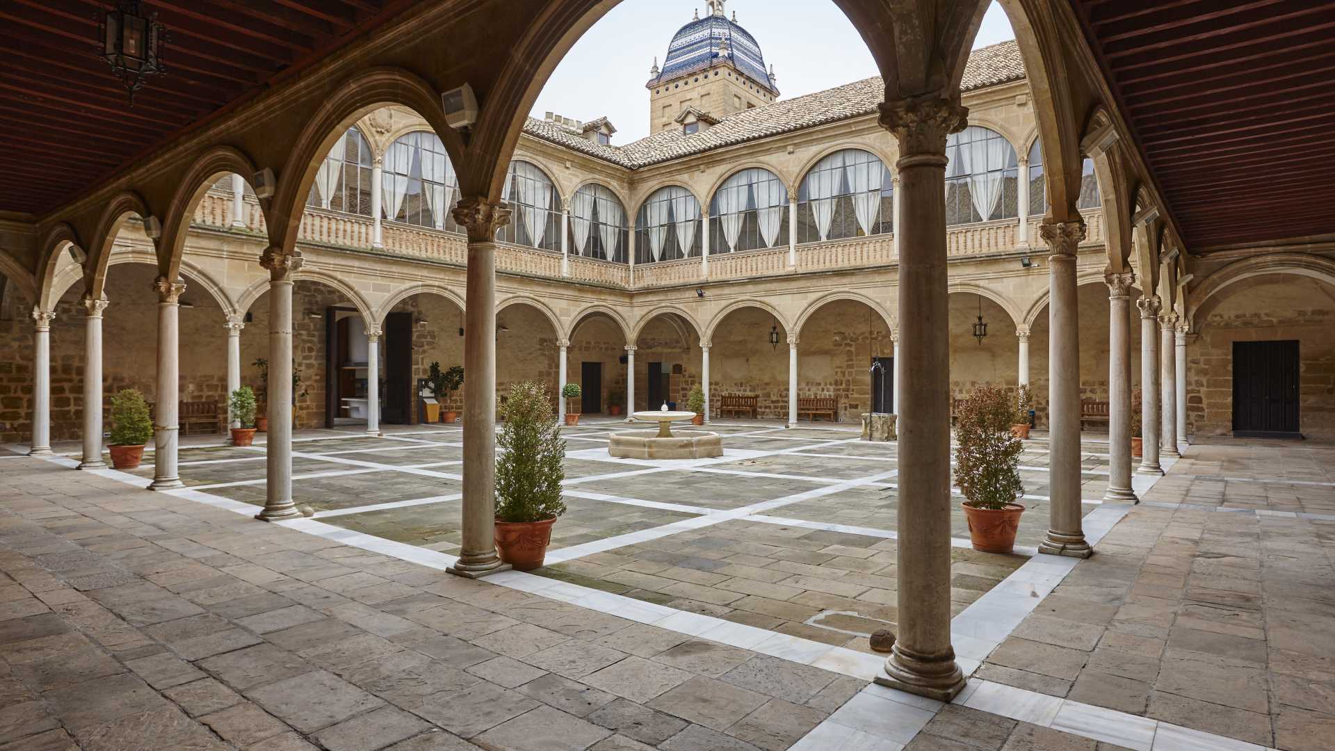 Eleganter Renaissance-Innenhof des Hospital de Santiago, Úbeda, mit gewölbten Kolonnaden und einem zentralen Brunnen.