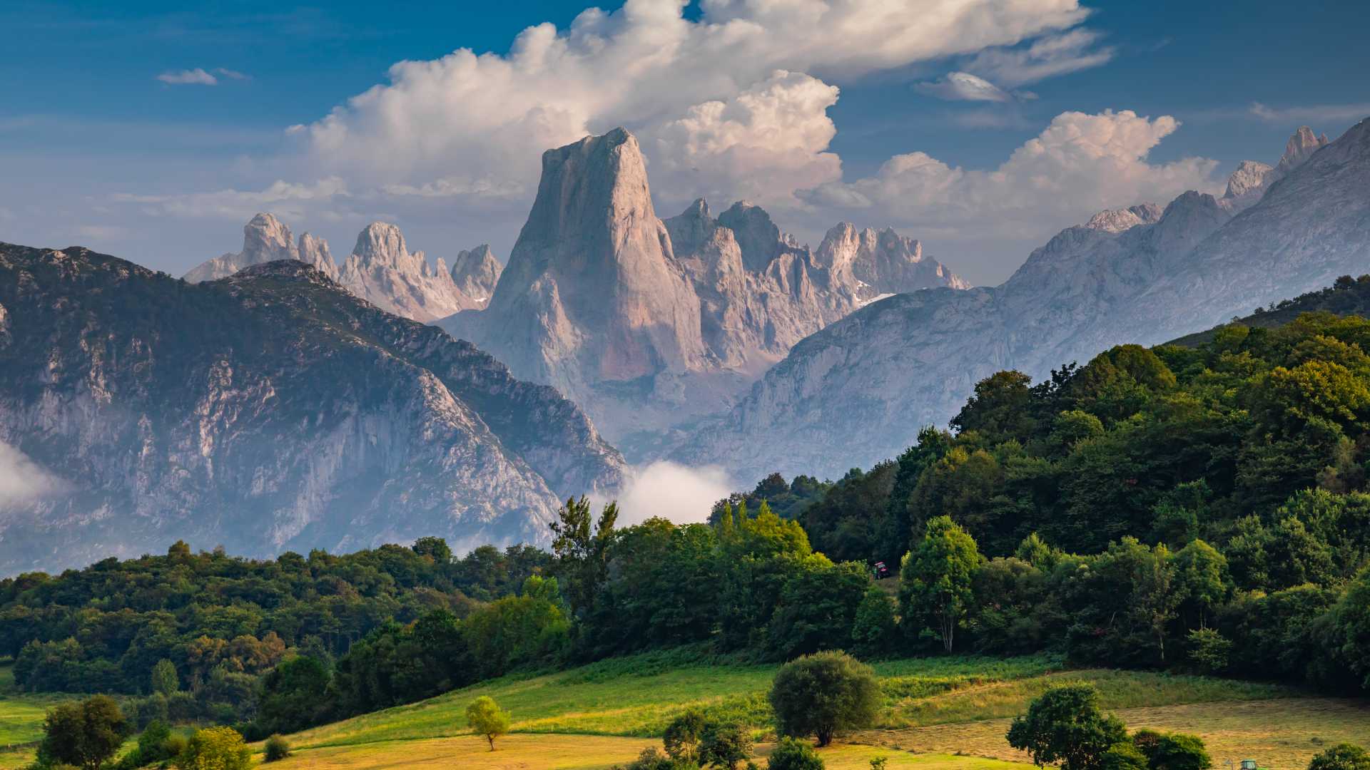De dramatische piek van Picu Urriellu torent boven de groene bossen in Asturië, Spanje.