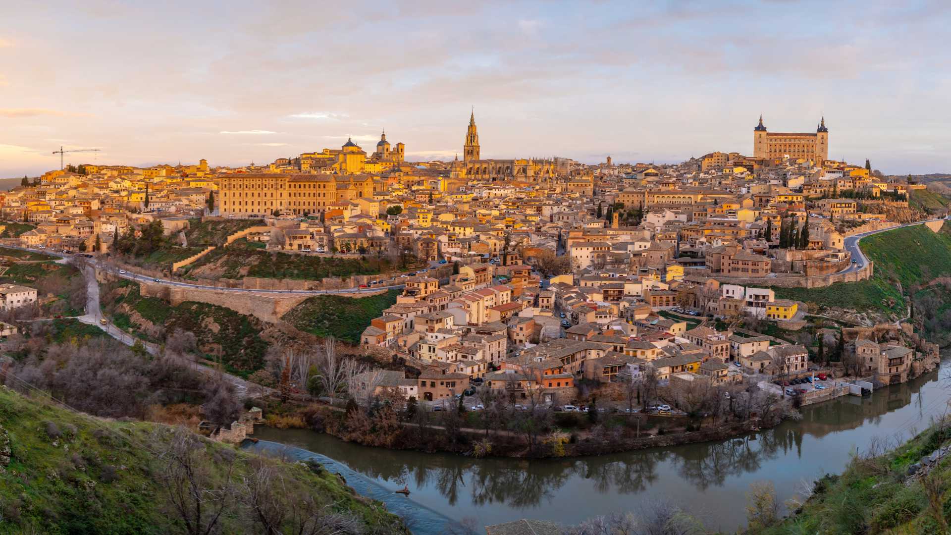 Sunrise illuminates the medieval city of Toledo, featuring the Alcázar and Toledo Cathedral in Spain.