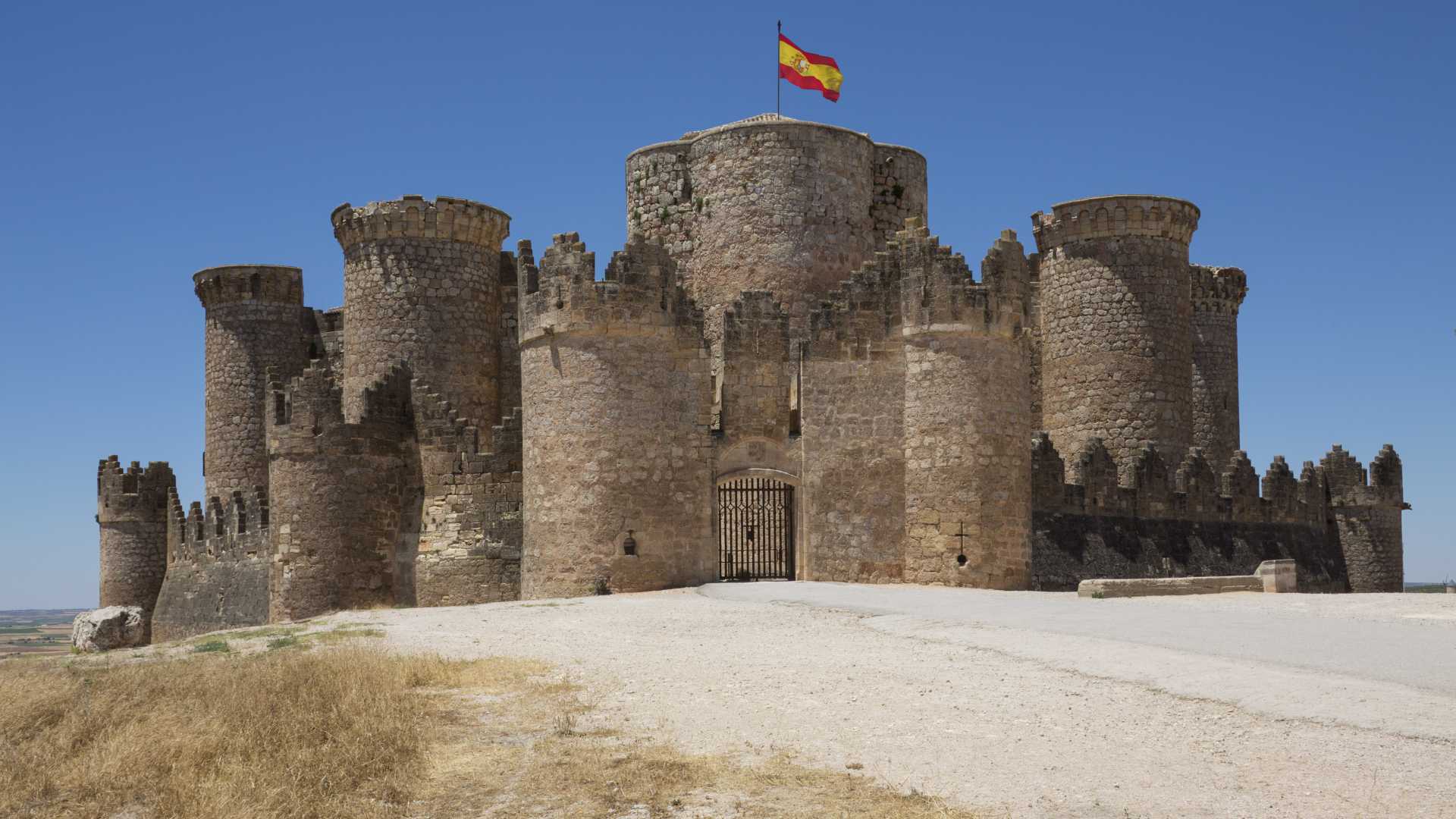 Belmonte Castle, a historic fortress in La Mancha, Spain, under a clear blue sky.