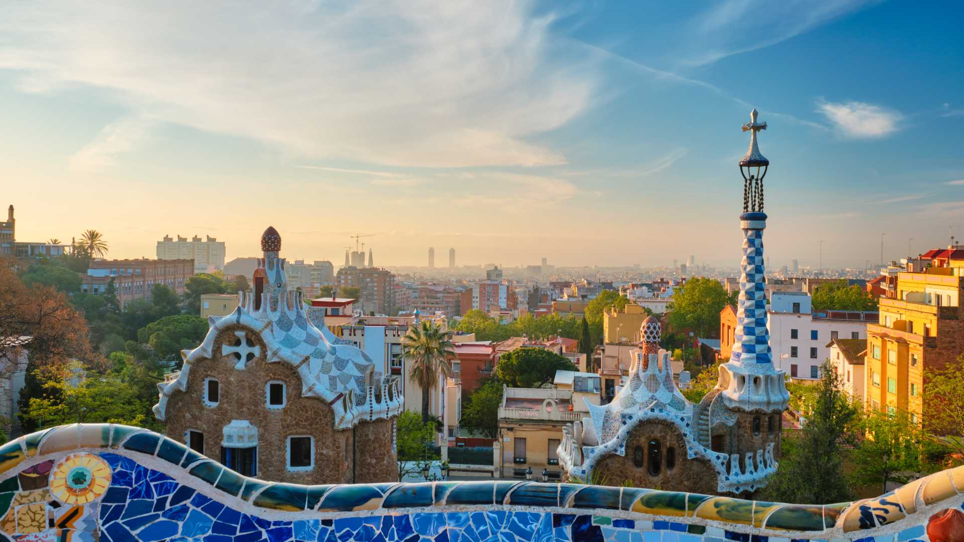 Barcelona skyline vanaf Park Güell met mozaïekarchitectuur bij zonsopgang.
