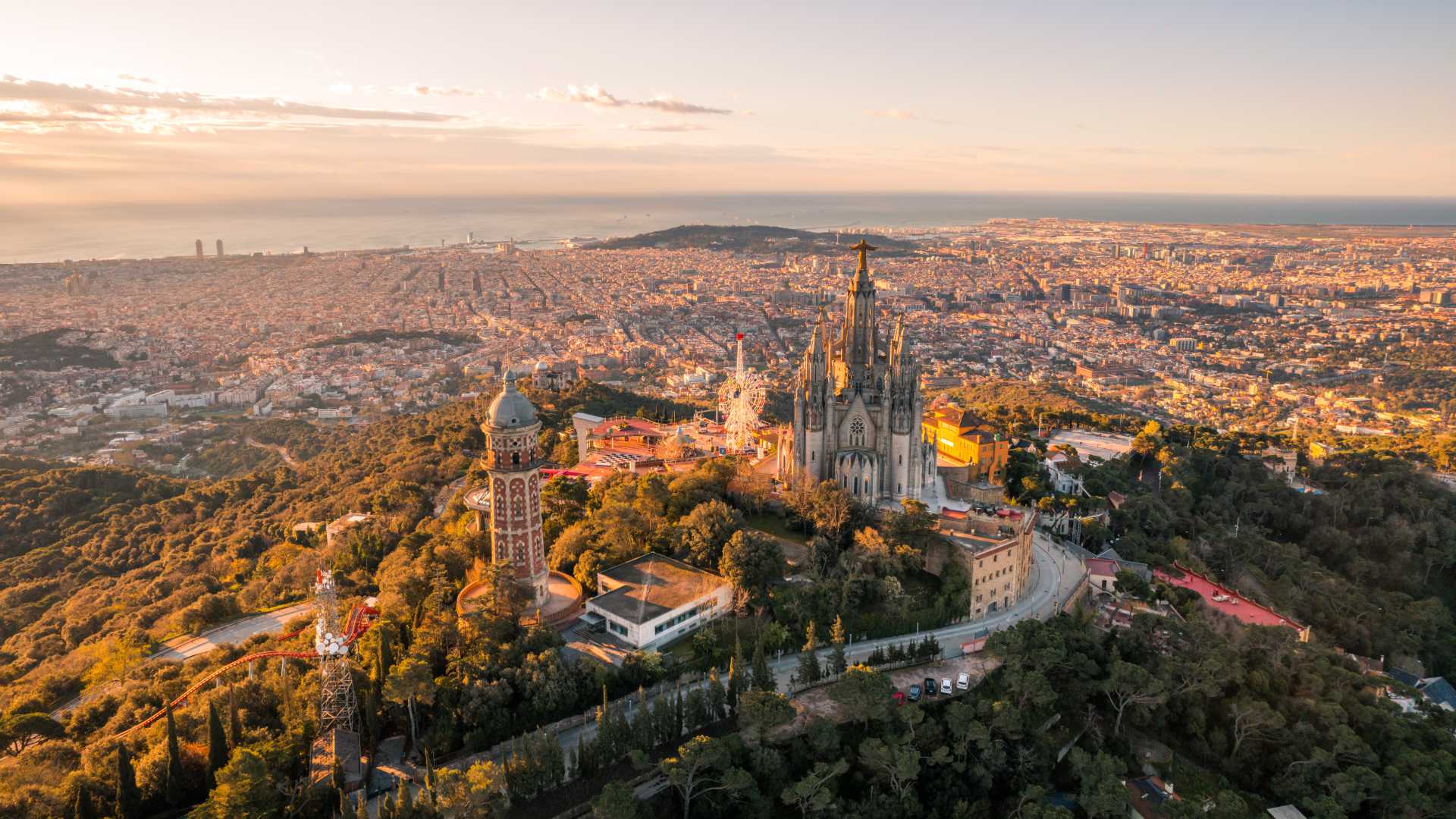 Zonsopgang in Barcelona over de skyline, gezien vanaf de berg Tibidabo, met de Sagrat Cor Tempel.