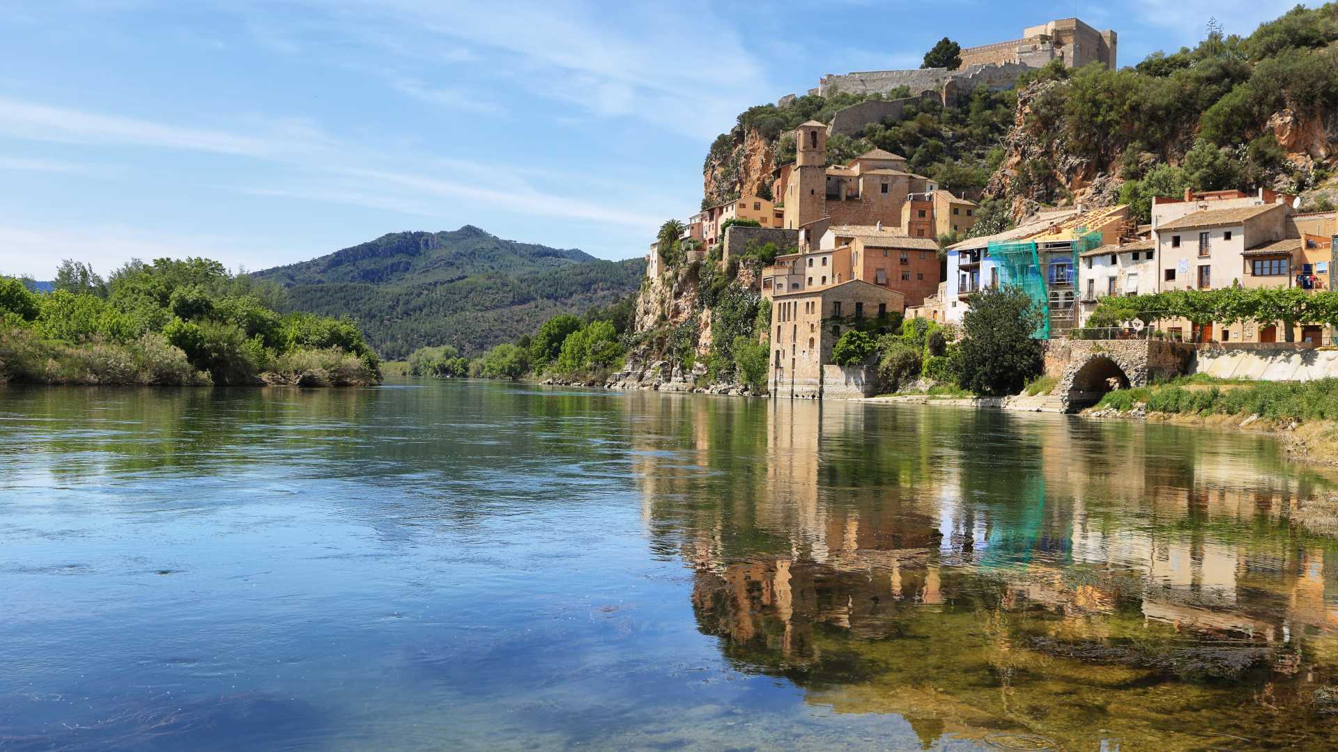 Het dorp en kasteel van Miravet, dramatisch gelegen boven de serene rivier de Ebro in Catalonië, Spanje.